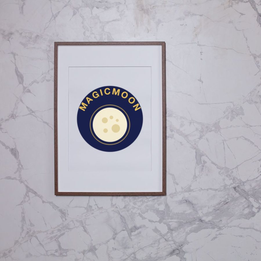 Framed poster on a marble wall showing a full moon artwork with the word MAGICMOON curved around it